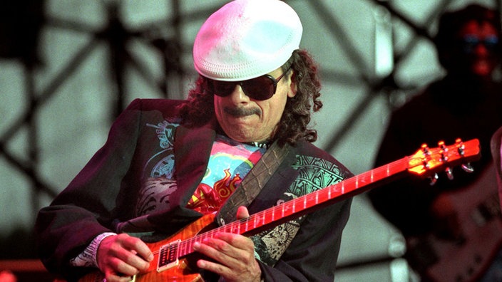 Carlos Santana mit weißer Kappe und Gitarre bei Live-Konzert (2009)