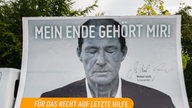 Ein Lkw transportiert ein Transparent mit dem Schriftzug "Mein Ende gehört mir" und dem Bild von Schauspieler Michael Lesch