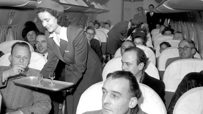 Swiss-Air-Stewardess serviert Getränke, 1947