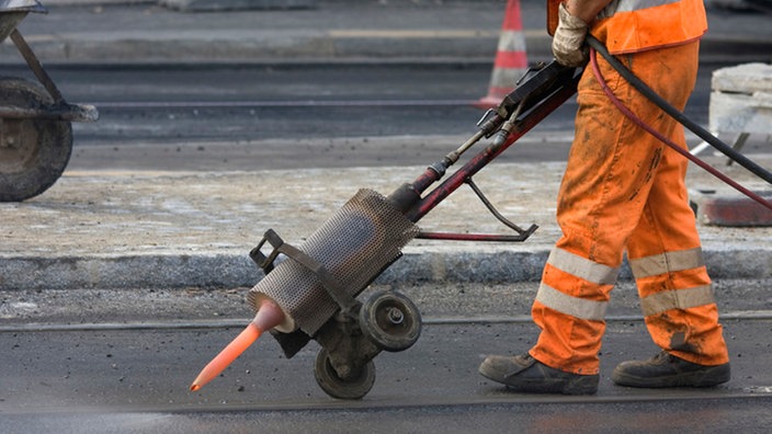 Arbeiter reinigt ein Schiene mit Heißluft