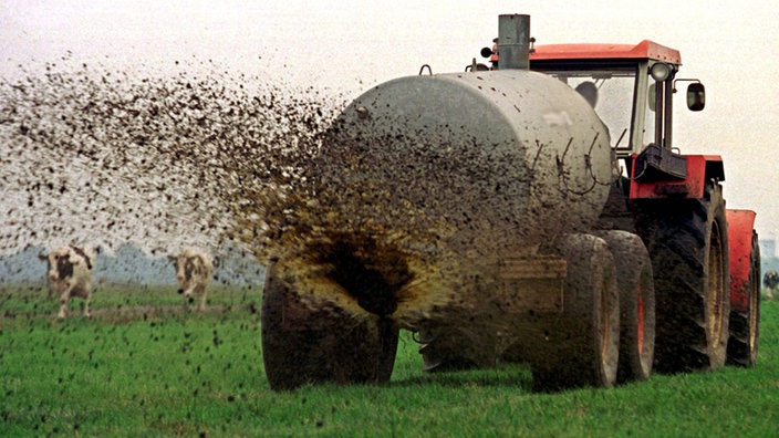 Traktor verteilt Gülle auf einem Feld