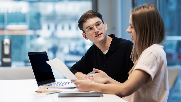 Freunde schreiben gemeinsam eine Bewerbung am Laptop