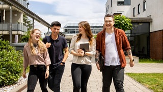 3 junge Menschen vor einer LED-Wand