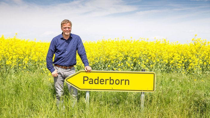 Manfred Schumacher vor einem Ortsschild der Stadt Paderborn