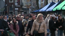 Das Bild zeigt eine Einkaufsstraße voller Menschen.