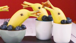 Bananendelfine schwimmen in einer Tasse gefüllt mit Blaubeeren. 