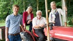 Margit Paschen mit ihren Kindern Eva und Martin und Vater von Margit auf einem roten Trecker