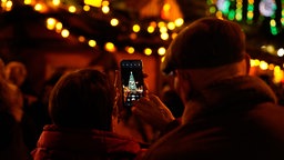 Ein Weihnachtsbaum wird fotografiert.