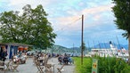 Das Bild zeigt einen Biergarten am See.