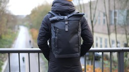 Eine Person trägt einen Rucksack.