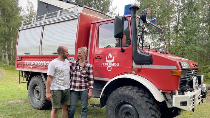 Auf dem Bild sieht man David und Alexandra vor dem Unimog