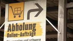 Das Bild zeigt ein Hinweisschild zum Abholbereich in einem Baumarkt