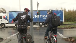 Zwei Fahrradfahrer stehen an einer roten Ampel