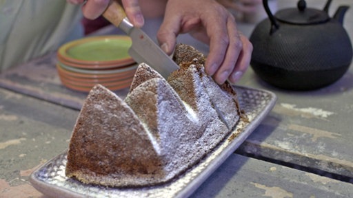 Apfelkuchen vom Keramiker wird angeschnitten