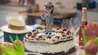 Torte mit Kirschen, in der Mitte kleine Figur