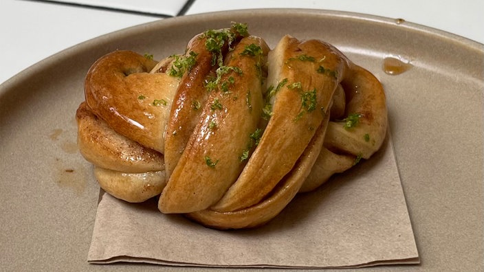 Das Bild zeigt Franz Buns mit Gewürzglasur auf einem braunen Teller serviert.