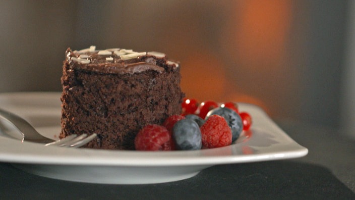 Ein Stück Schokokuchen garniert mit roten Beeren