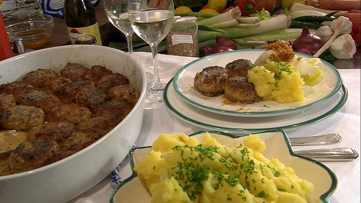 Butterschnitzel in einer Backform, außerdem eine Portion mit Pürree auf einem Teller angerichtet