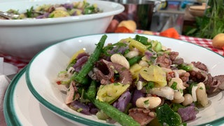 Kartoffelsalat mit zweierlei Bohnen und Oktopus auf einem Teller angerichtet