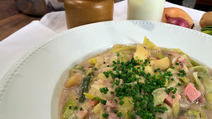 Lauch-Kartoffelsuppe mit Buttermilch in einem Teller angerichtet und mit Schnittlauchröllchen garniert