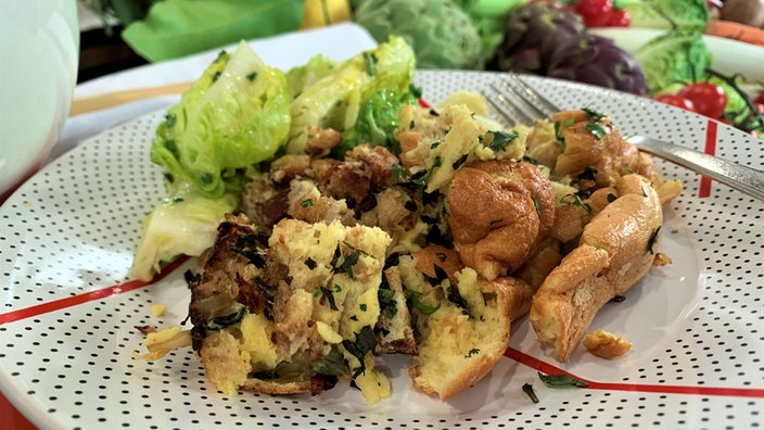 Eine Portion Käseschmarrn mit grünem Salat auf einem Teller angerichtet