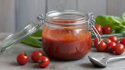 Das Bild zeigt ein Glas mit Tomatensugo.