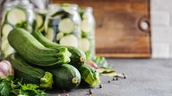 Zucchinis liegen Knoblauch und Pfeffer auf dem Tisch. 