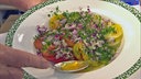 Tomatensalat mit Zwiebel-Petersilien-Marinade auf einem tiefen Teller angerichtet