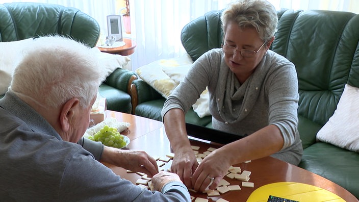 Aud dem Bild sind zwei Menschen zu sehen, die ein Spiel spielen.