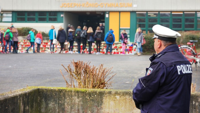 Schüler stehen vor Schulbeginn vor dem Joseph-König-Gymnasium in Haltern am See vor Kerzen. 