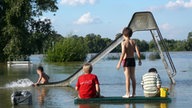 Vier Kinder nutzen einen vom Rhein überschwemmten Spielplatzim Kölner Stadtteil Rodenkirchen, 2007