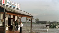 Die Wirtsleute des Restaurantes 'Zur Rheinfähre' in Xanten stehen auf der Terasse ihres Lokals, das von allen Seiten von Wasser umgeben ist, 1998